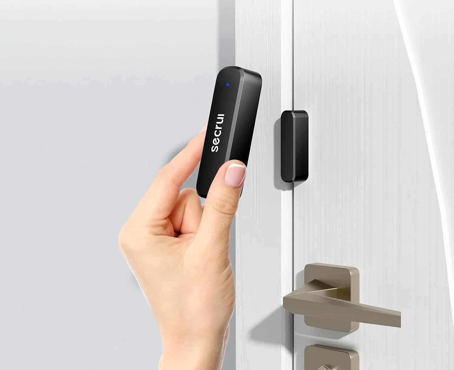 A hand pressing a SECRUI door sensor onto a door beside its magnet